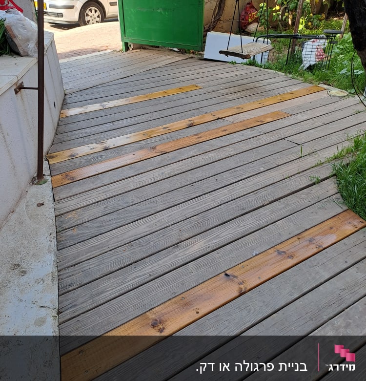 דק עץ עם לוחות עץ בהירים בגינה